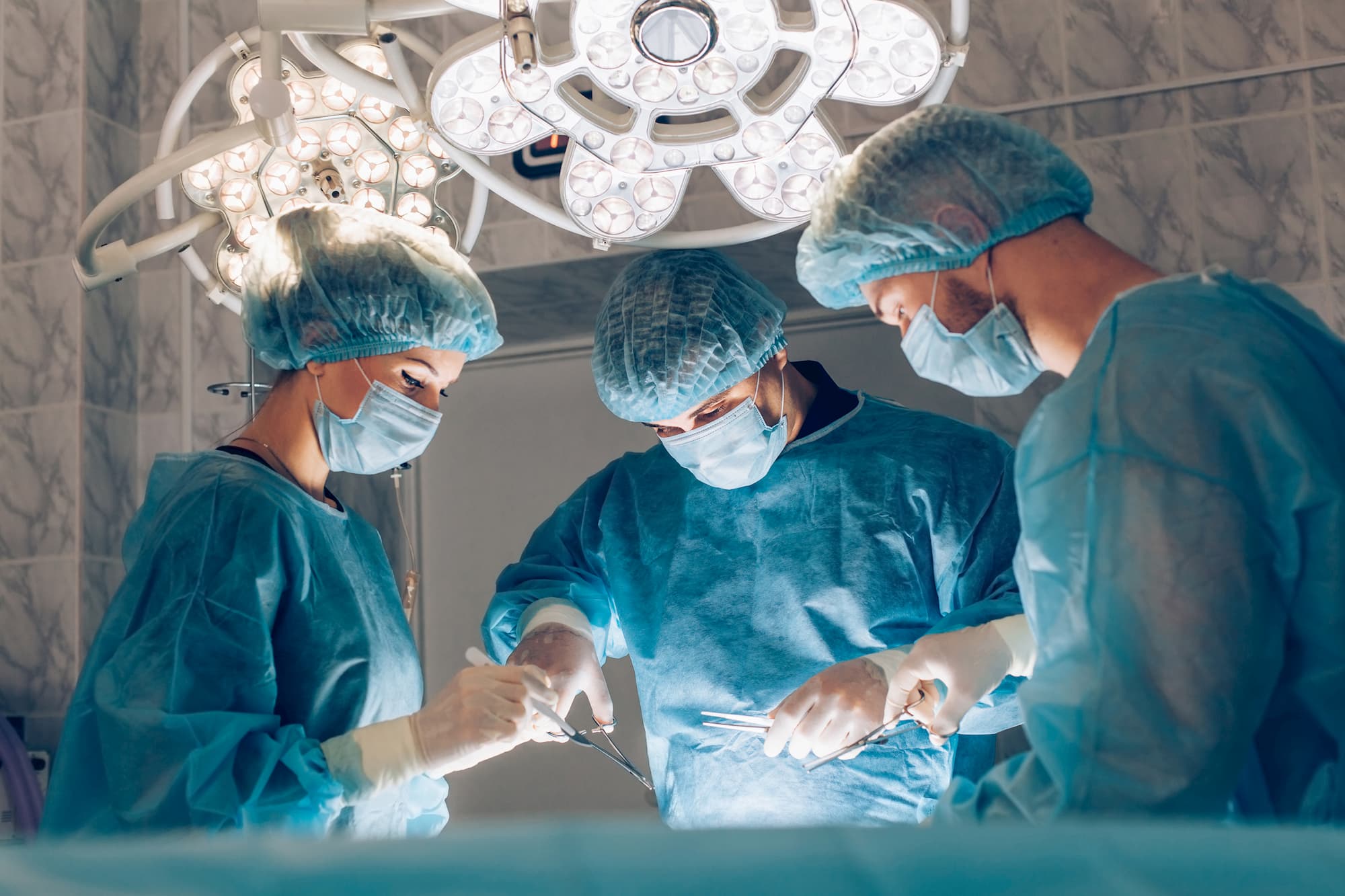 3 surgeons operating on a patient