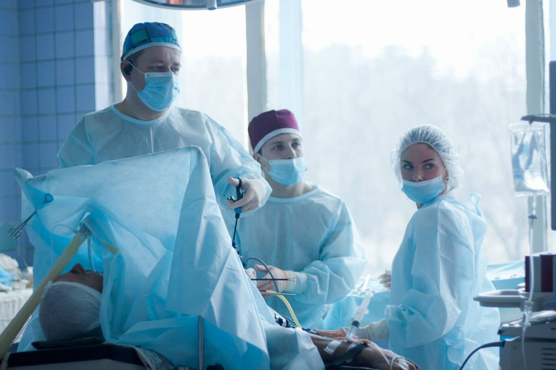 3 surgeons carrying out gallbladder removal surgery on a patient